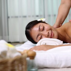 Young Asian woman receiving an oil massage on her back at spa salon by professional masseuse, Spa treatment and aroma oil massage concept